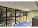 Relaxing screened porch offers an outdoor living space with views of the backyard and mature trees at 409 Olive Ave, Nokomis, FL 34275