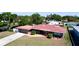 Aerial view of a beautiful home with a red roof, spacious yard, and a serene pond nearby at 4616 22Nd W Ave, Bradenton, FL 34209