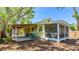 Rear exterior view of yellow house, showcasing a screened-in porch and covered parking at 4721 Garcia Ave, Sarasota, FL 34233