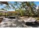 Spacious backyard with mature trees, covered lounge area, and outdoor seating at 4916 Hidden Oaks Trl, Sarasota, FL 34232