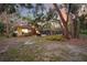 Inviting backyard at dusk featuring a pool, outdoor seating area, and lush landscaping with mature trees at 4916 Hidden Oaks Trl, Sarasota, FL 34232