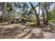 Spacious backyard featuring mature trees, a pool, and a patio with outdoor seating area perfect for entertaining at 4916 Hidden Oaks Trl, Sarasota, FL 34232