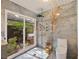 Modern bathroom featuring a walk-in shower with unique tile work and a view to the greenery outside at 4916 Hidden Oaks Trl, Sarasota, FL 34232
