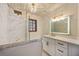 Stylishly appointed bathroom features a shower with marble tile, a modern vanity, and decorative lighting at 4916 Hidden Oaks Trl, Sarasota, FL 34232