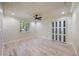 Bedroom with light wood floors, closet, and view of the surrounding landscaping at 4916 Hidden Oaks Trl, Sarasota, FL 34232