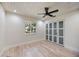 Bright bedroom with light wood floors, closet, and view of the surrounding landscaping at 4916 Hidden Oaks Trl, Sarasota, FL 34232