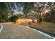 Twilight photo displays a home with a winding driveway accentuated with landscape lighting at 4916 Hidden Oaks Trl, Sarasota, FL 34232