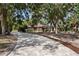 Long paved driveway leading up to this home with shade trees and meticulous landscaping at 4916 Hidden Oaks Trl, Sarasota, FL 34232