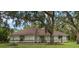 Charming single-story home with a well-maintained lawn and mature trees providing ample shade at 4916 Hidden Oaks Trl, Sarasota, FL 34232