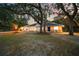Inviting single-story home featuring well-maintained landscaping, exterior lighting, and mature trees at 4916 Hidden Oaks Trl, Sarasota, FL 34232
