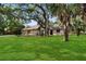 Charming home with a lush green lawn and mature trees offering ample shade at 4916 Hidden Oaks Trl, Sarasota, FL 34232