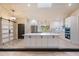 Modern kitchen with white cabinets, a large island with bar stools, and stainless steel appliances at 4916 Hidden Oaks Trl, Sarasota, FL 34232