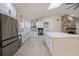 Beautiful open kitchen features an island, modern appliances, and a stone fireplace at 4916 Hidden Oaks Trl, Sarasota, FL 34232