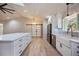 Open-concept space with kitchen and fireplace in living room with light wood floors and skylight at 4916 Hidden Oaks Trl, Sarasota, FL 34232