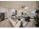 Staged living room with wood floors, modern furniture, a stone fireplace, and an open view of the kitchen at 4916 Hidden Oaks Trl, Sarasota, FL 34232