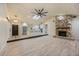 Open concept living room and kitchen featuring wood floors, modern lighting and a stone fireplace at 4916 Hidden Oaks Trl, Sarasota, FL 34232