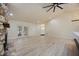 Bright living room with wood-look floors, a stone fireplace, and a large window overlooking the backyard at 4916 Hidden Oaks Trl, Sarasota, FL 34232