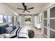 Bright main bedroom with a fan, white shiplap ceiling, and sliding doors leading to the bathroom at 4916 Hidden Oaks Trl, Sarasota, FL 34232