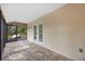 Covered outdoor patio with stone flooring leading to an open deck at 4916 Hidden Oaks Trl, Sarasota, FL 34232