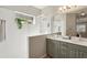 Bright bathroom featuring a double vanity, large mirror, and a glass-enclosed shower at 5023 Brickell Park Cv, Bradenton, FL 34211