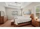 Spacious bedroom showcasing a king-sized bed, tray ceilings, and a wooden dresser set at 5023 Brickell Park Cv, Bradenton, FL 34211