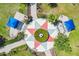 Overhead shot of a colorful community park with seating, geometric designs, and lush landscaping at 5023 Brickell Park Cv, Bradenton, FL 34211
