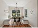 Bright dining area featuring built-in bench seating, modern chandelier, and a large window with natural light at 5023 Brickell Park Cv, Bradenton, FL 34211