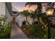 Close up of home entrance with tropical landscaping and walkway lighting at dusk at 5023 Brickell Park Cv, Bradenton, FL 34211