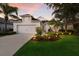 Charming home with a two-car garage, green lawn and a well-maintained front yard at dusk at 5023 Brickell Park Cv, Bradenton, FL 34211