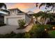 Charming home with a two-car garage, green lawn and a well-maintained front yard at dusk at 5023 Brickell Park Cv, Bradenton, FL 34211