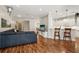 Open-concept living area with hardwood floors, a sectional sofa, and a view into the kitchen at 5023 Brickell Park Cv, Bradenton, FL 34211