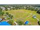 Aerial view of a grassy field with soccer goals and shade structures for community recreation at 5023 Brickell Park Cv, Bradenton, FL 34211