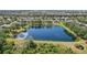 Overhead shot featuring a peaceful pond surrounded by vibrant greenery and the clear sky's reflection at 5023 Brickell Park Cv, Bradenton, FL 34211