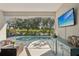 Relaxing screened lanai with seating area, TV, and a pool overlooking lush backyard scenery at 5023 Brickell Park Cv, Bradenton, FL 34211