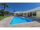 Sparkling pool with brick trim and view of yellow house and manicured lawn at 508 70Th St, Holmes Beach, FL 34217