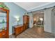 Living room featuring wood floors, blue walls, modern fixtures and an open entry way to a dining room at 5251 Mahogany Run Ave # 521, Sarasota, FL 34241