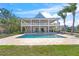 Beautiful backyard pool with stone patio, seating area, and a spacious two-story waterfront home with balconies at 526 56Th St, Holmes Beach, FL 34217