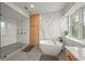 Beautiful bathroom with free standing tub, glass shower, custom cabinets, and quartz accent wall at 526 56Th St, Holmes Beach, FL 34217