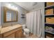 Bathroom with gray walls, a wood framed mirror and a shower behind a patterned shower curtain at 526 56Th St, Holmes Beach, FL 34217