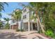 Attractive multi-story home with a brick driveway, covered entry, and verdant tropical landscaping at 526 56Th St, Holmes Beach, FL 34217