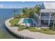 Beautiful waterfront pool area with a jacuzzi, lounge chairs, and lush landscaping surrounding a coastal home at 526 56Th St, Holmes Beach, FL 34217