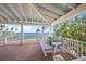 Inviting porch with a cozy swing bed, offering a relaxing outdoor space to enjoy stunning water views at 526 56Th St, Holmes Beach, FL 34217