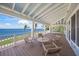 Covered porch with comfortable seating to take in the water views and lush greenery for relaxation at 526 56Th St, Holmes Beach, FL 34217