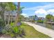 Scenic waterfront property featuring lush landscaping, boat dock, and charming multi-story homes under a sunny sky at 526 56Th St, Holmes Beach, FL 34217
