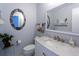 This bathroom features a stylish round mirror, a marble countertop, and a contemporary faucet at 5630 Golf Pointe Dr # 206, Sarasota, FL 34243