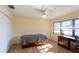 This bedroom has a ceiling fan, wood floors, large window, and under-bed storage at 5630 Golf Pointe Dr # 206, Sarasota, FL 34243