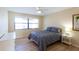 Bright bedroom featuring a ceiling fan, wide window, wood floors and a comfortable bed with stylish gray comforter at 5630 Golf Pointe Dr # 206, Sarasota, FL 34243