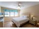 This bedroom features a cozy bed, ceiling fan, and bright natural light at 5630 Golf Pointe Dr # 206, Sarasota, FL 34243
