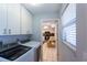 Convenient laundry room with washer, dryer, and adjacent kitchen view, maximizing space and functionality at 5630 Golf Pointe Dr # 206, Sarasota, FL 34243