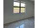 Clean and well-lit bedroom with tile flooring and a view of the outdoors through a large window at 5632 Summit Pointe Cir # 101, Bradenton, FL 34210